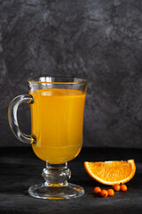 Beautiful fortified sea buckthorn drink in a glass on a dark background