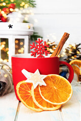 Christmas and New Year decorations with red cup, dry orange slices, fir branch on white background. Copy space, bokhe