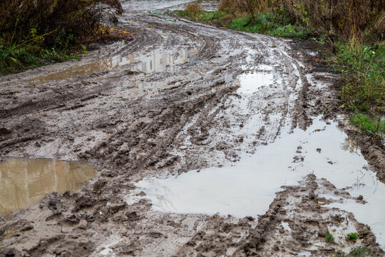 dirty clay mud road with tire tracks - closeup with selective focus and blur