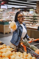 African woman with shopping cart. Girl in a supermarket.