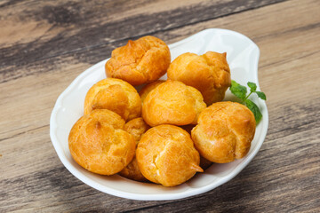 Sweet tasty profiteroles heap in the bowl