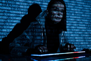 Internet, crime, cyber attack, system breaking concept. Blue neon light background. Woman hacker is working on a code with digital interface all around.
