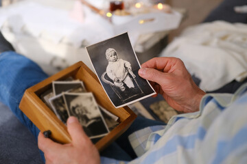 an elderly man looks through his old photographs of 1960-1965, the concept of nostalgia and...