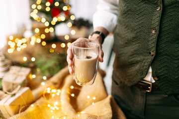 Man holding coffee with festive garland