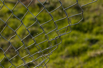 Chicken wire fence. Broken fence. Metal wire. Hole in the fence. 