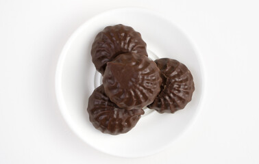 Dessert chocolate marshmallow is in a white plate on a light background. The view from the top. The concept of desserts.