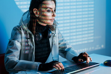 Internet, crime, cyber attack, system breaking concept. Blue neon light background. Woman hacker is...