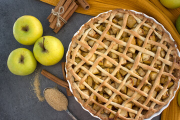 Lattice decorated apple pie on a table. Top view photo of apple tart on yellow fabric background. ...