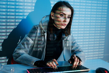 Internet, crime, cyber attack, system breaking concept. Blue neon light background. Woman hacker is working on a code with digital interface all around.