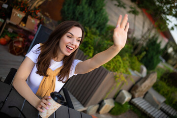 Obraz na płótnie Canvas smiling young woman freelancer drinking coffee on cafe terrace