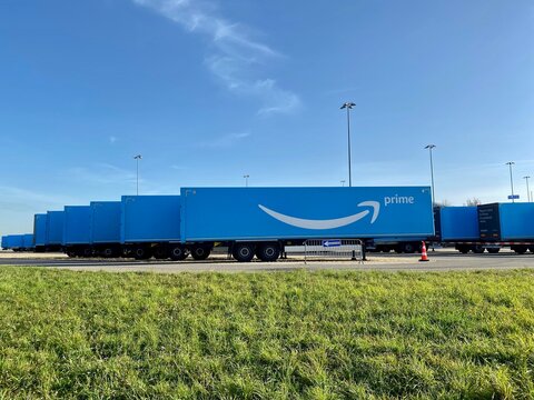 Stuttgart, Germany - November 8, 2020: Multiple blue Amazon prime trailers are parked within a waiting are close to the airport ready for delivery of Christmas sales in Stuttgart, Germany.