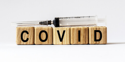 Text COVID made from wooden cubes. White background
