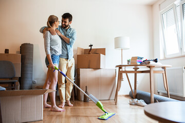 Couple moving into new house.They unpacking and cleaning new home.	