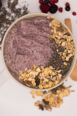 Mousse de color rosa con muesli desdde vista cenital y fondo blanco