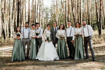 friends and friendship at the wedding,boys and girls with newlyweds in the forest,wedding group photo,wedding day of the groom with the bride,a cheerful company of friends for newlyweds