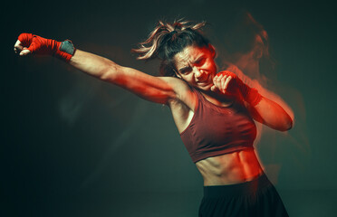 Sporty female training in stylish sportswear in studio. Women's sport fighting workout. Long exposure shot