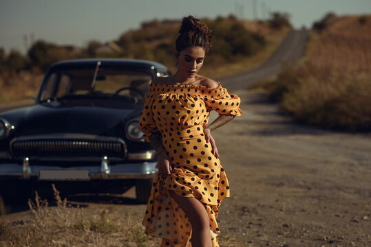 Gorgeous young woman wearing classy yellow spot print off shoulders dress walking on the roadside