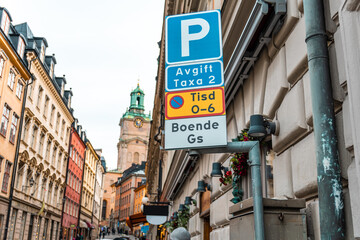 STOCKHOLM, SWEDEN - JANUARY, 2020: Swedish car parking road sign with parking rules in the background of city streets and buildings