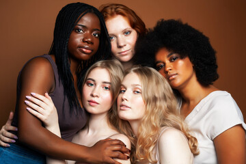 Obraz premium young pretty african and caucasian women posing cheerful together on brown background, lifestyle diverse nationality people concept