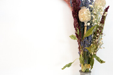 Gray concrete vase with bright dried bouquet flowers in front of the white wall modern decoration of home, copy space