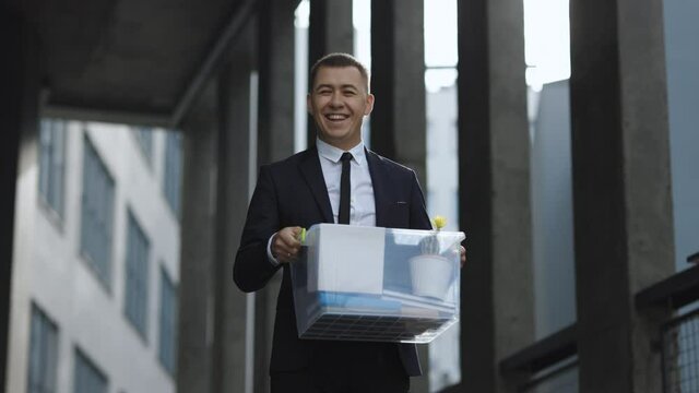 Portrait happy male office worker with box of personal stuff. Unemployment concept. Left without money. Businessman lost job. Fired man outdoors. Happy Jobless person