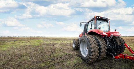 Modern tractor cultivates fertile land under a cloudy sky