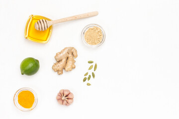 Raw ginger root and dry ginger, honey and turmeric on white