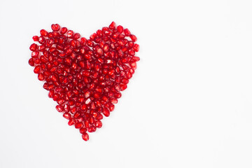 Fototapeta na wymiar Pomegranate seeds in heart shape plate 