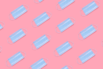 Colorful pink background with medical masks. Pattern from medical masks. High quality photo