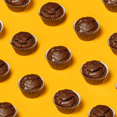 Сhocolate cupcakes or cookies pattern on a yellow background. Summer minimalism. Isometric flat lay. Top view. Food concept.