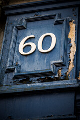 Number sixty on weather painted blue door