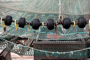 Fischernetze und Kette mit schwarzen Schwimmern an Bord deines Krabbenkutter im Hafen von...