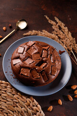 Chocolate cake with chocolate pieces on a brown background