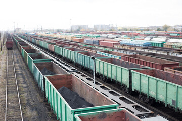 Fototapeta na wymiar Export shipment. View from the bridge to freight trains. Top view of old rusty wagons on the railway. Heavy industry. Railroad station. Transport