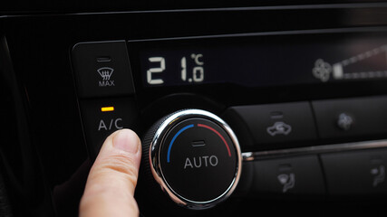 set up air conditioner in the car. Hand turns air conditioner ring. Display indicates temperature...
