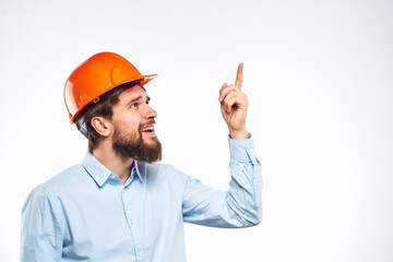 Man in orange hard hat industry engineer work professional light background