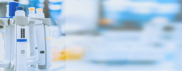 medical and research banner. Laboratory pipettes on blurred laboratory background. Research and...