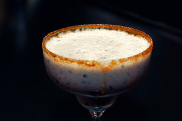 Beautiful glass of milkshake drink coctail close up with sugar on borders, gourmet cuisine, no alcohol