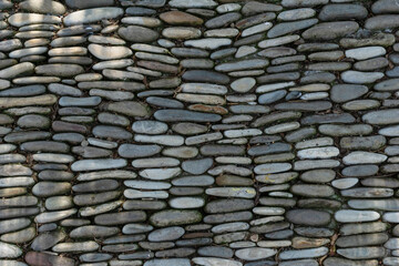 natural background made of horizontal rows of flat gray stones stacked close to each other. Copy space for text.