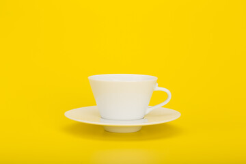 Minimalistic still life with cup of coffee on yellow background