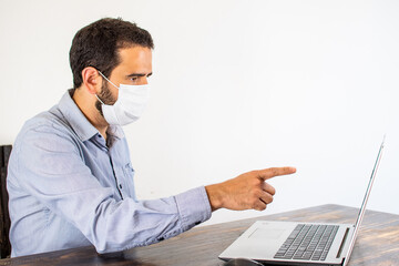 man with chinstrap working from home pointing at the computer