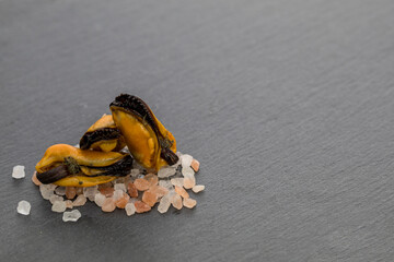 a stone plate, on it mussels on salt