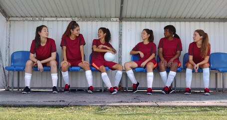 Group of teenagers sitting on bench talking after soccer practice - Powered by Adobe