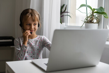 Little girl using video chat on laptop at home. Space for text