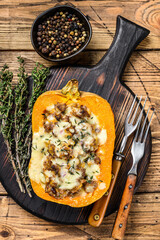 Cooked pumpkin stuffed with ground mince meat, vegetables and herbs. wooden background. Top view