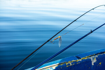 Fishing accessories baubles with a hook on a blue water background close up selective focus