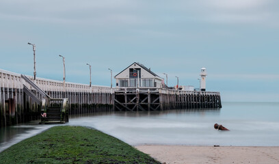 Old pier and breakwater on the Belgian coast in Blankenberge. Long exposure image.