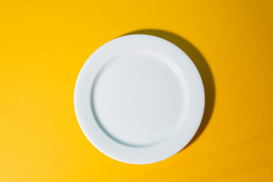 Top View On An Empty White Platter On Yellow Background