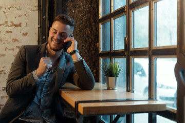 Happy young businessman with mobile phone