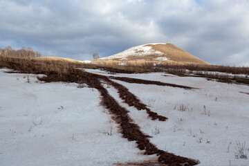 Bashkir hills in early spring with remnants of snow and dry grass.